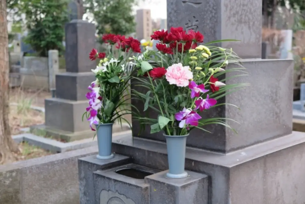 お墓の両脇に花立が設置され、色鮮やかな供花が供えられている光景