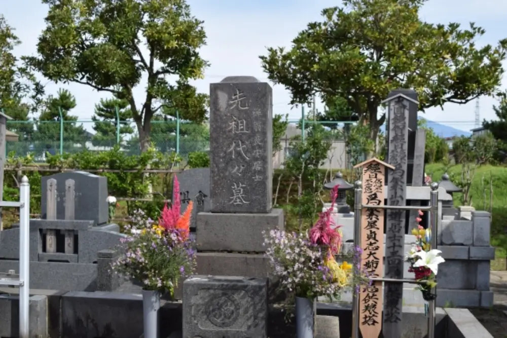 花が手向けられた墓石と卒塔婆が並ぶ先祖代々の墓