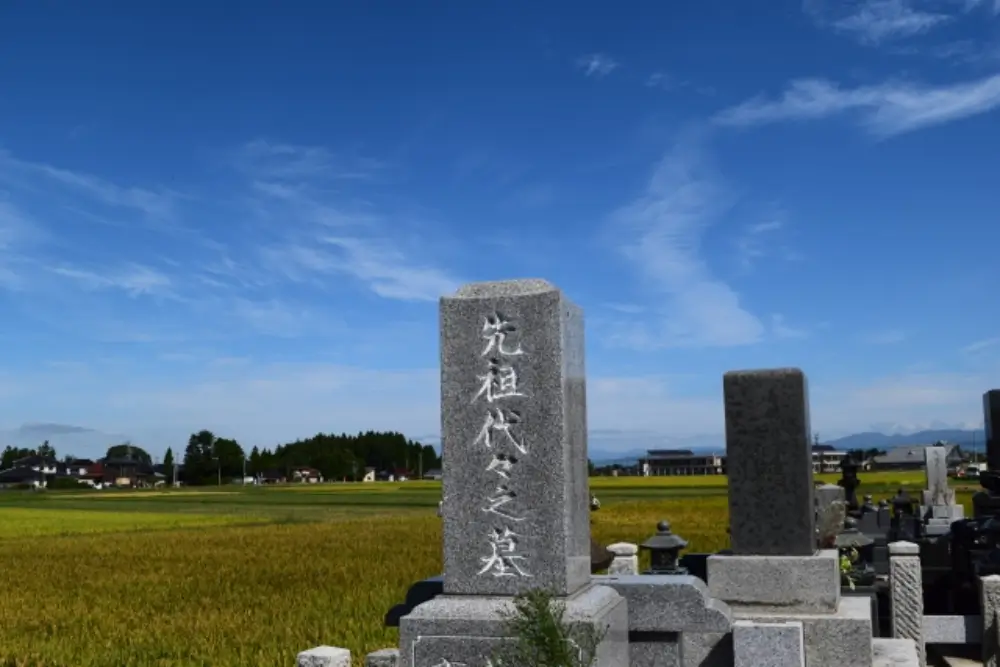 田舎の田園に建つ先祖代々の墓石の写真