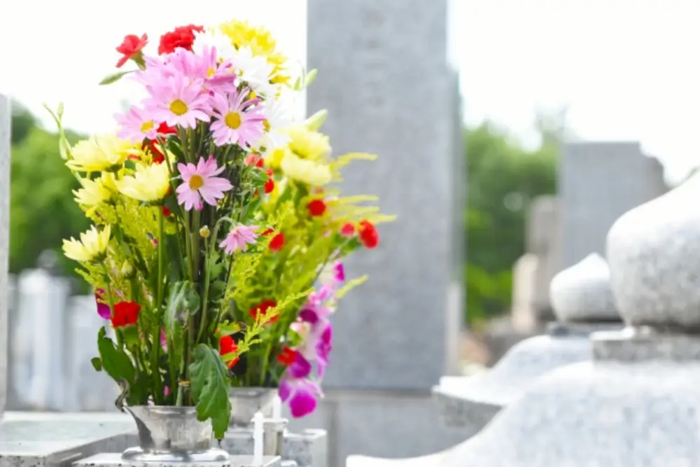 お墓に供えられた色とりどりの花が風に揺れている様子