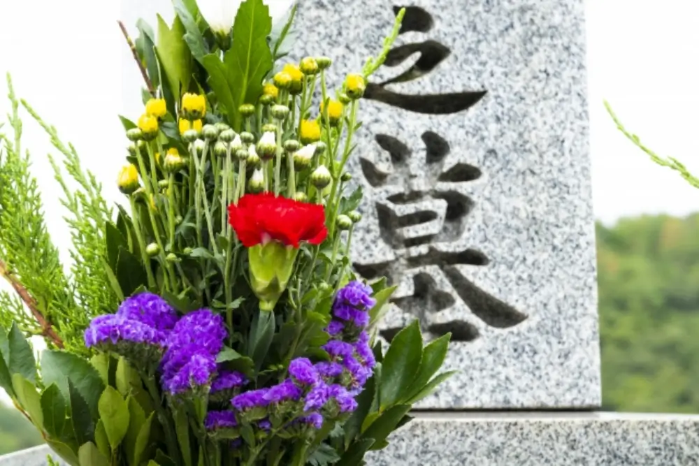 墓石に供えられた紫・赤・黄色の仏花
