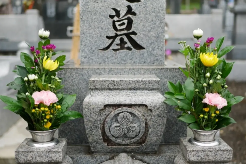 「墓」と彫られた墓石と、左右に供えられた綺麗な供花