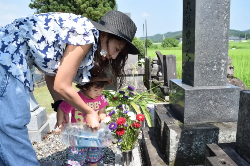 夏にお墓参りをする親子の様子