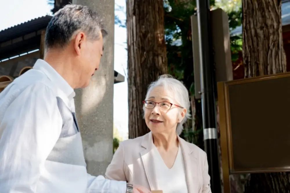 高齢の夫婦が霊園で会話をしてお墓参りについて相談している場面